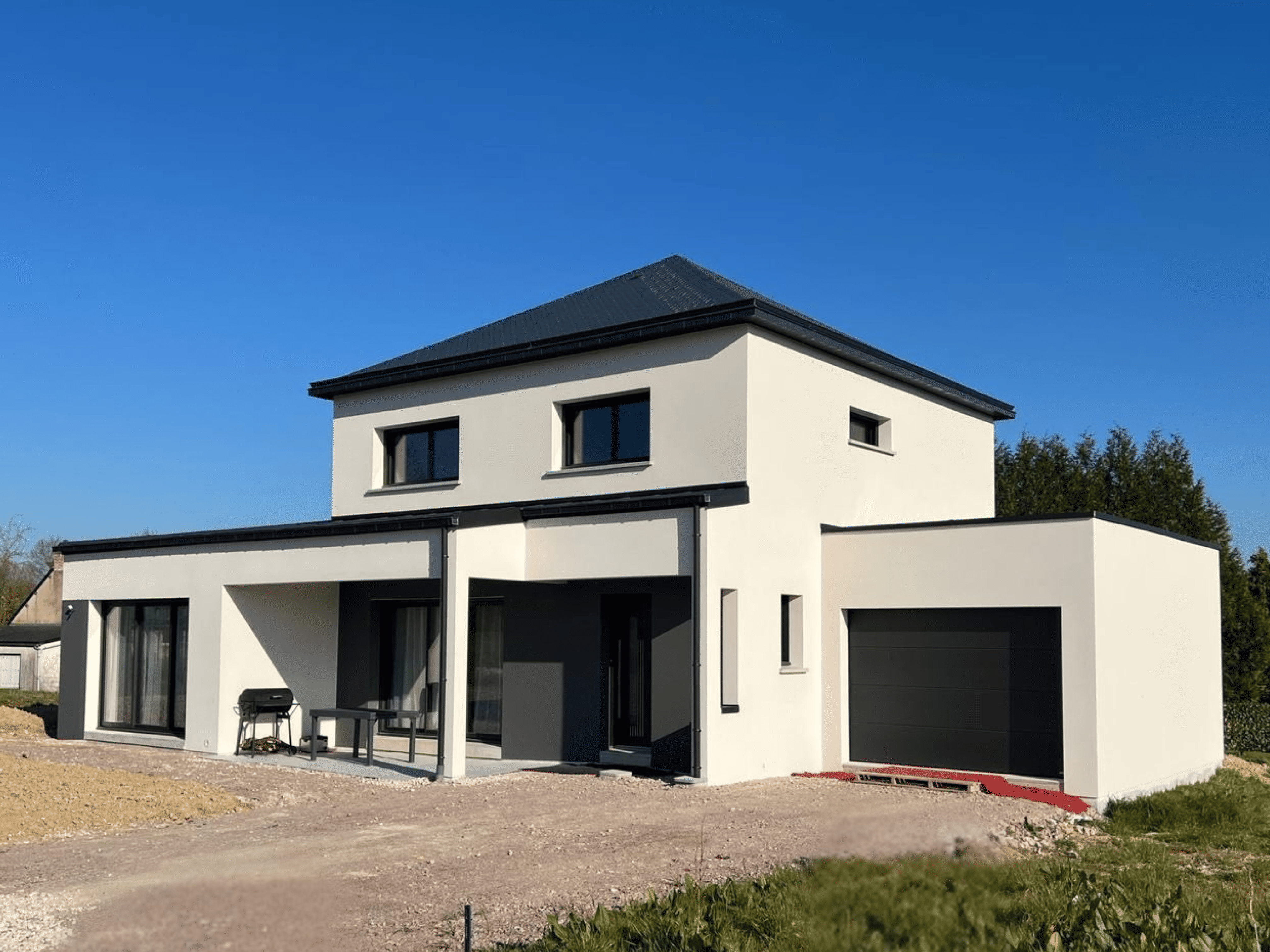 Maison contemporaine à étage avec toiture 4 pans, façades en enduit blanc, garage intégré, terrasse couverte et grandes baies vitrées Maison contemporaine à étage avec toiture 4 pans, façades en enduit blanc, garage intégré, terrasse couverte et grandes baies vitrées